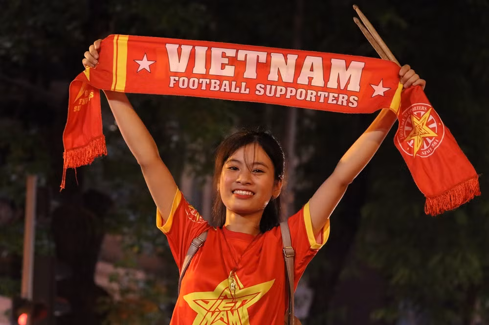 Chuẩn bị đủ các dụng cụ như áo, cờ... CĐV nữ thuộc Hội CĐV VFS Miền Bắc này luôn là người cầm nhịp cho những màn cổ vũ của các "đồng đội". Theo chia sẻ của bạn nữ, đây chẳng khác gì một khán đài D8 của sân Mỹ Đình vì họ được chơi những điệu cổ vũ mà đã ngấm vào máu.