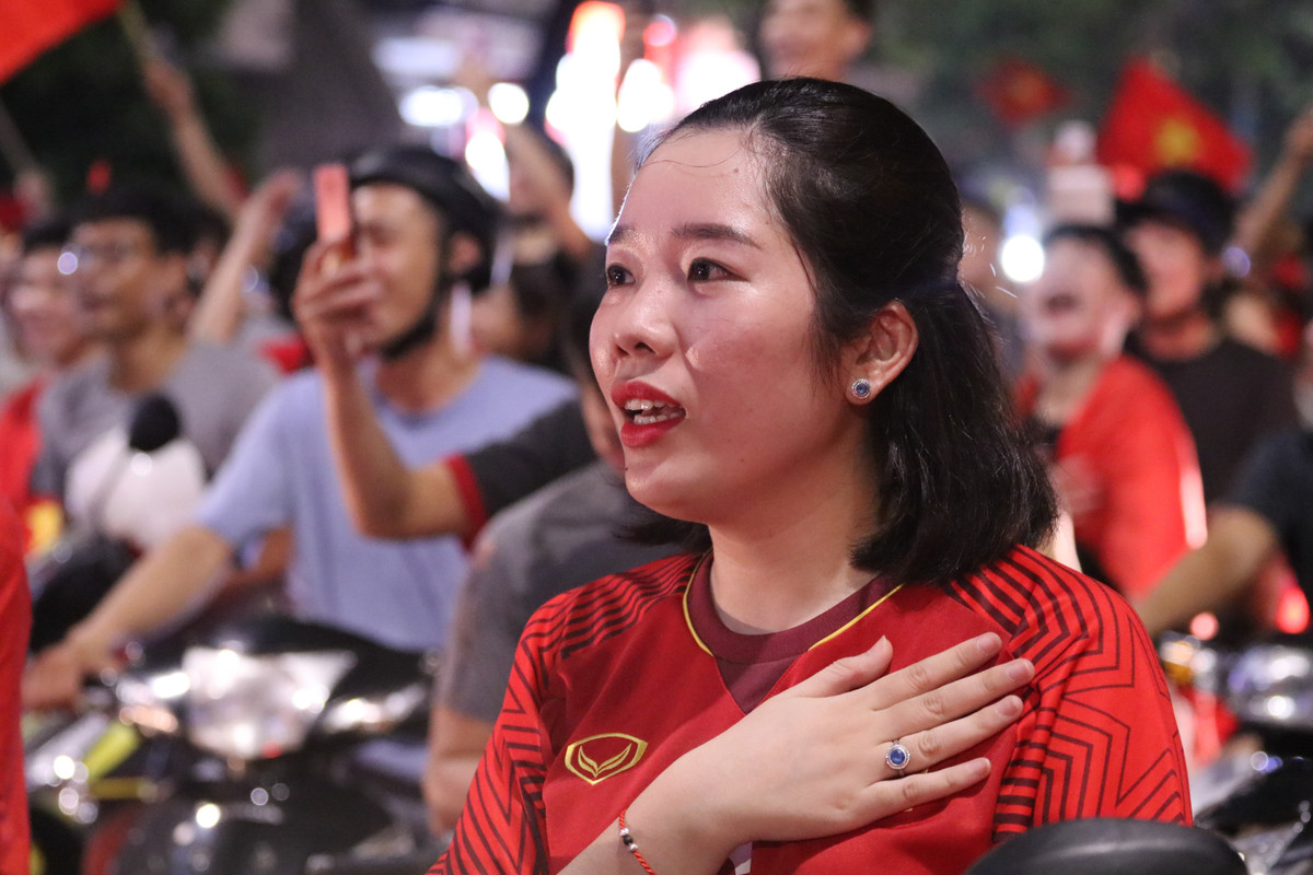 Một nữ CĐV rất tâm trạng trong bài Quốc ca được mở trên phố giữa dòng người đông đúc.