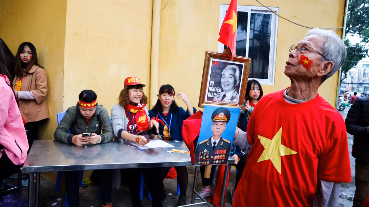 Một cựu chiến binh mang ảnh Đại tướng Võ Nguyên Giáp để mang vào SVĐ Hàng Đẫy cổ vũ các cầu thủ U23 Việt Nam chuẩn bị thi đấu.