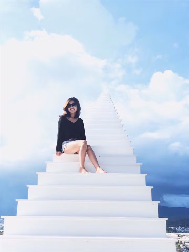 Được thiết kế khá đơn giản bằng những tấm gỗ đóng thành cầu thang và được sơn màu trắng tinh tuyền, chiếc cầu thang vô cực này hòa vào nền trời xanh tạo nên background sống ảo cực đẹp.