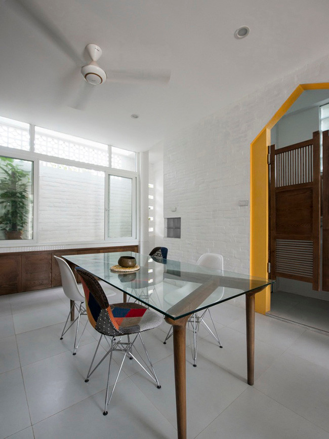 Bàn ăn mặt bằng kính với những chiếc ghế “cọc cạch” thể hiện cá tính của gia chủ.