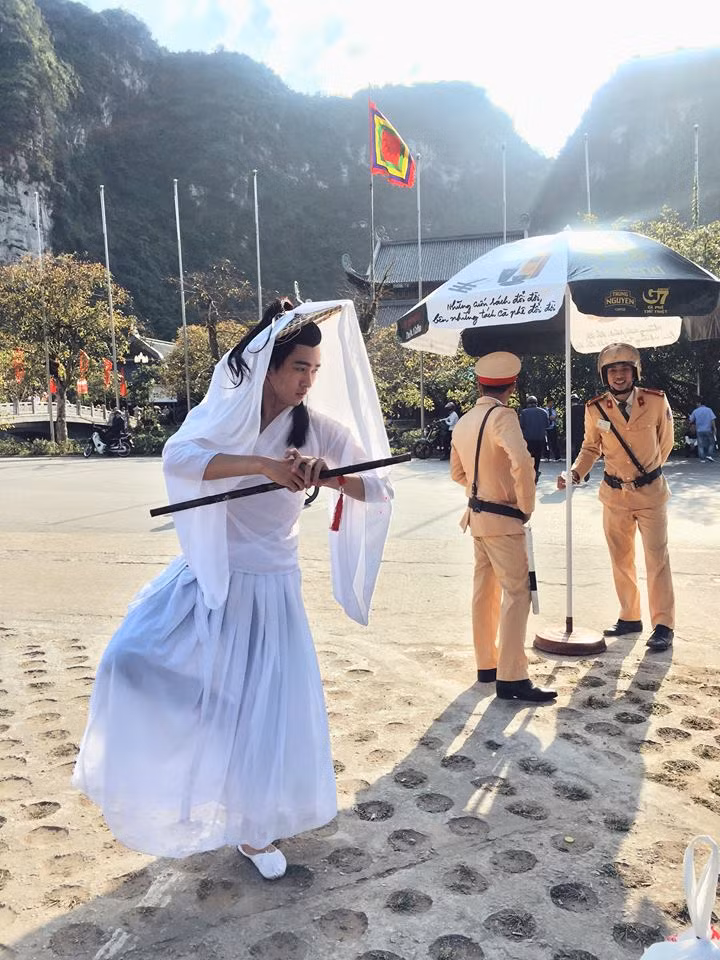 Cụ thể, xuất phát từ trang cá nhân của nickname Jin Phạm, những bức ảnh ghi lại hai thanh niên nam nữ trong trang phục cổ trang lấy mình mẫu là hai nhân vật Cô Cô và Dương Quá đứng sau chốt của các chiến sĩ CSGT tại Việt Nam được hàng ngàn bạn trẻ, dân mạng truyền tay nhau. Ảnh: FB Jin Phạm.