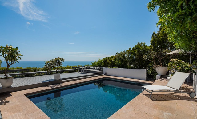 Căn nhà còn có những tiện ích sang trọng khác như bể bơi ngoài trời, phòng tập thể dục hiện đại, và một nhà để xe rộng lớn.