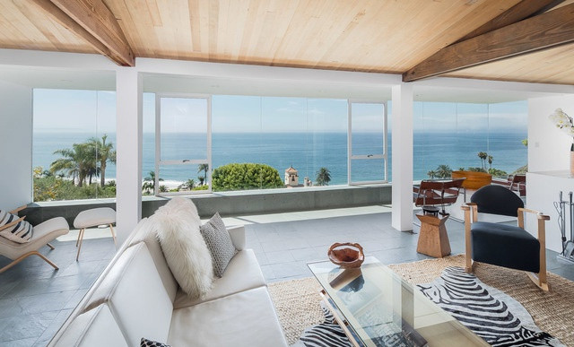 Phòng khách căn biệt thự sang trọng, thoáng đãng với những bức tường kính đem đến cảnh sắc đại dương bao la.