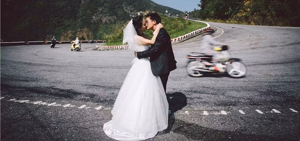 Người xem giật mình thon thót khi ekip chụp hình đứng giữa 2 làn xe máy, ô tô lên, xuống, giữa khúc cua đan vào nhau như mắc cửi.