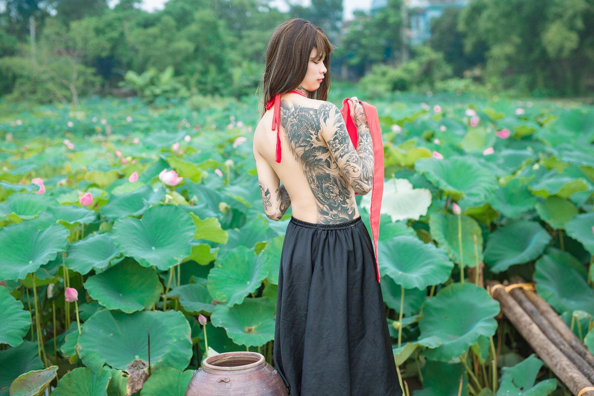 Hình ảnh một nam sinh xăm trổ, đội tóc giả, khoe lưng trần bên ao sen nhanh chóng trở thành chủ đề nóng trên mạng xã hội. Theo tìm hiểu của dân mạng, chàng trai này có tên Tuấn Lâm, hiện sinh sống tại Việt Trì và làm nghề xăm nghệ thuật.