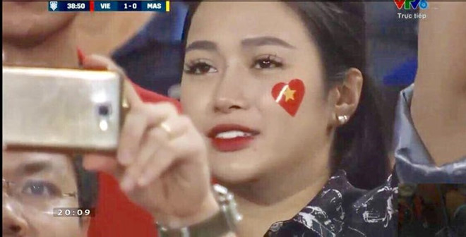 Cũng trong trận đội tuyển Việt Nam gặp Malaysia ngày 16/11, khoảnh khắc Vũ Thị Trang (23 tuổi) giơ điện thoại lên chụp ảnh cũng thu hút nhiều sự chú ý. 9X đã tốt nghiệp đại học và có công việc kinh doanh của riêng mình.