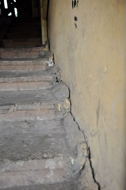 Phần mạch nối giữa cầu thang và tường chịu lực của khu nhà đang bị bóc tách tạo thành những vết nứt chạy dài từ tầng 1 lên đến tầng 5.