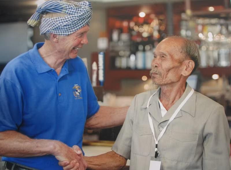 Ông Bảy bắt tay với một phi công Mỹ sau khi ông tặng chiếc khăn rằn (Ảnh: Nhân vật cung cấp).