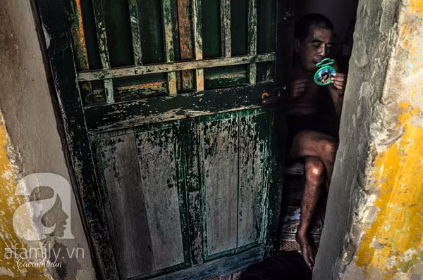 Người đàn ông chăm chú tỉa bộ râu của mình sau khe cửa hẹp.