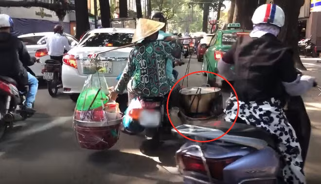 Nhằm đảm bảo an toàn cho bản thân, nhiều người đi đường chỉ biết né tránh khi phương tiện chở "nước sôi, lửa bỏng" của chị bán hàng rong này chạy qua.