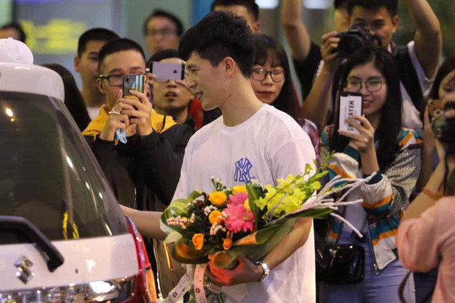 Đình Trọng nhận được rất nhiều hoa và quà từ người hâm mộ có mặt tại sân bay Quốc tế Nội Bài.