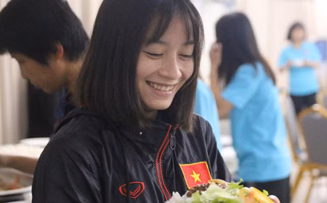 Nụ cười hạnh phúc của nữ cầu thủ đội tuyển Việt Nam khi bữa ăn được cải thiện.