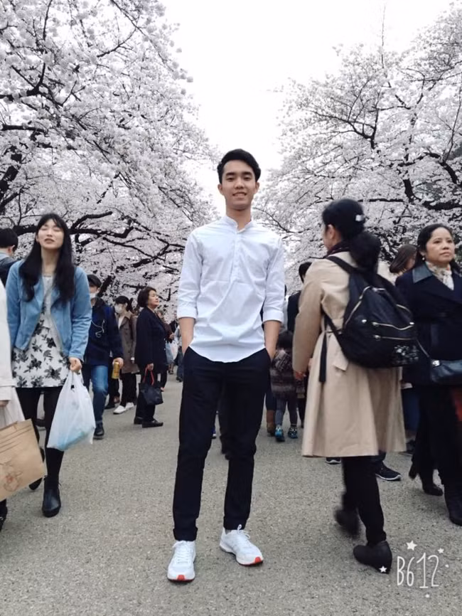 Giữa nhiều người qua lại, anh chàng vẫn có thể nổi bật với sắc hoa anh đào trắng. Ảnh: FB Long Tống.