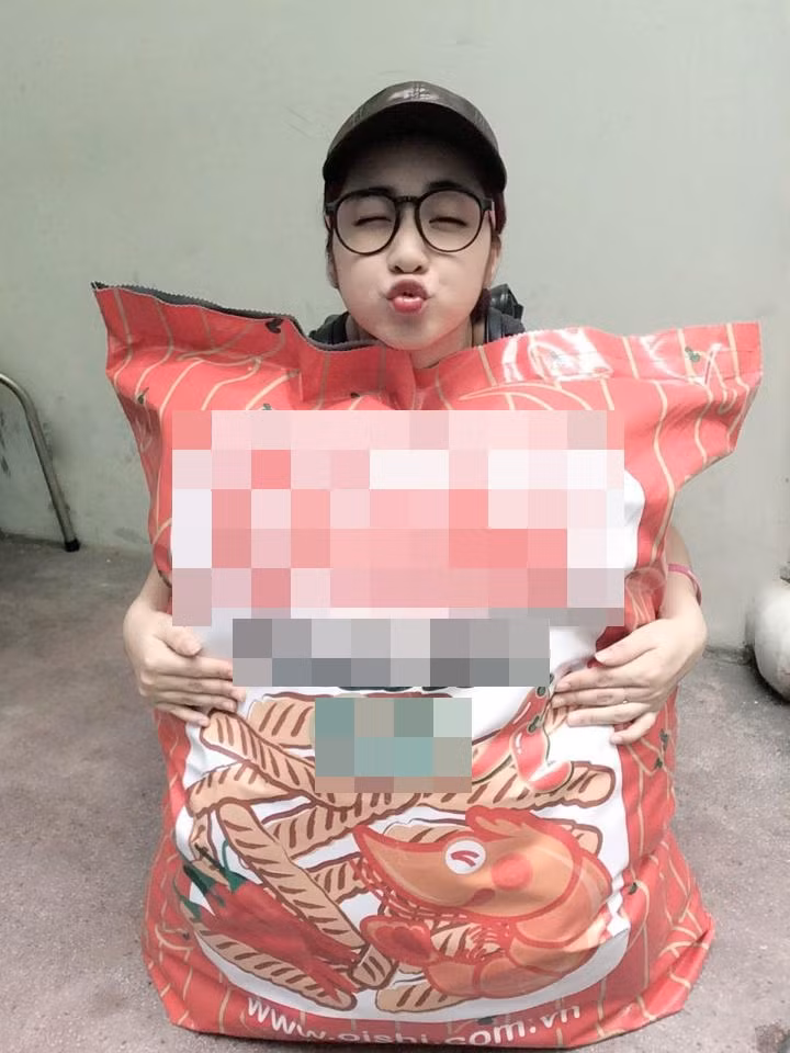 Hình ảnh Hòa Minzy chu mỏ chụp ảnh cùng chiếc gối ôm snack khổng lồ.