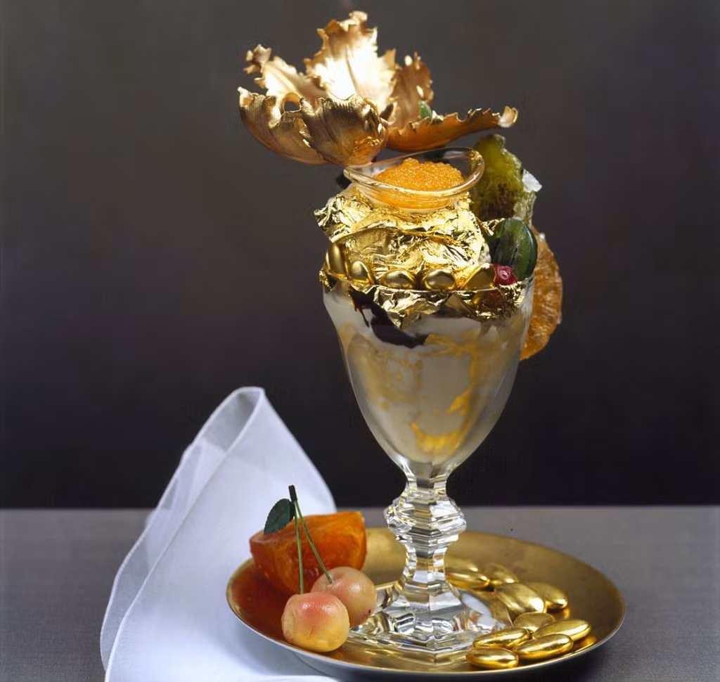 Golden Opulence Sundae là món tráng miệng nổi tiếng của nhà hàng Serendipity 3, New York, Mỹ. Món tráng miệng trị giá 1.000 USD này gồm có kem vani Tahitian, vani Madagascar, chocolate Amedei Porcelana, phủ bên ngoài vàng lá 24 carat. Ngoài một ly kem, thực khách còn có thể thưởng thức kẹo trái cây, hạnh nhân mạ vàng, nấm truffle, cherry, trứng cá muối, và tất cả đều nằm trong một chiếc ly pha lê Baccarat mà bạn có thể mang về nhà sau khi ăn xong. Ảnh: Cdn.