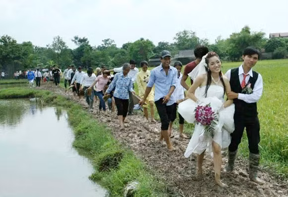 Cô dâu mặc váy cưới dài trắng khá vất vả để đi qua con đường đó. Cô dâu chú rể cùng nhau xách váy lên, chật vật bước từng bước một bên lề cỏ - đoạn đường được xem là khá khẩm hơn một chút.