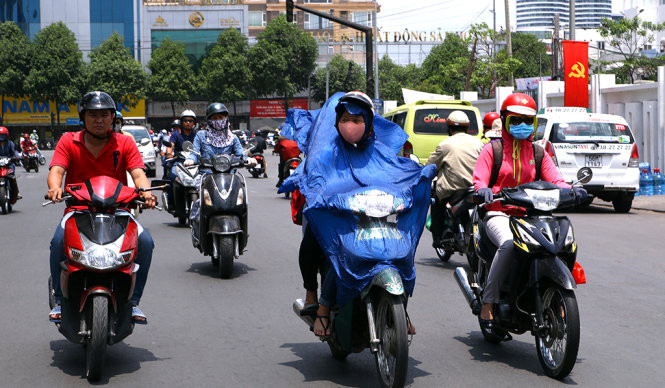 Dù trời không mưa nhưng những chiếc áo mưa được người dân sử dụng để làm giảm tác động của tia UV tới da.