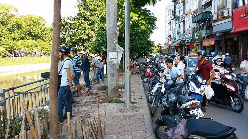 Rất nhiều người dân tụ tập hai bên bờ sông để xem câu cá. Đường Nguyễn Khang tắc một đoạn dài.