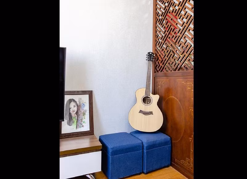 Vách ngăn gỗ giúp ngăn cách không gian phòng khách và bàn thờ. Nữ diễn viên không biết chơi guitar nhưng chuẩn bị sẵn một chiếc đàn để bạn bè đến chơi.
