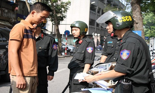 CSCĐ dừng xe kiểm tra người đi xe máy không đội mũ bảo hiểm. Ảnh: Tùng Lâm.