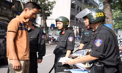 CSCĐ dừng xe kiểm tra người đi xe máy không đội mũ bảo hiểm. Ảnh: Tùng Lâm.