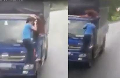 Hình ảnh một thanh niên đu trên tấm kính của xe tải tại vùng cao.