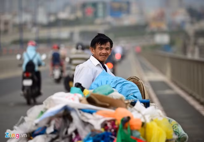 Ông Nguyễn Quang Dạo (quê Quảng Ngãi) vất vả đẩy xe muối iốt qua cầu Sài Gòn. Gió to làm bay những túi nilon khiến ông phải dừng lại.
