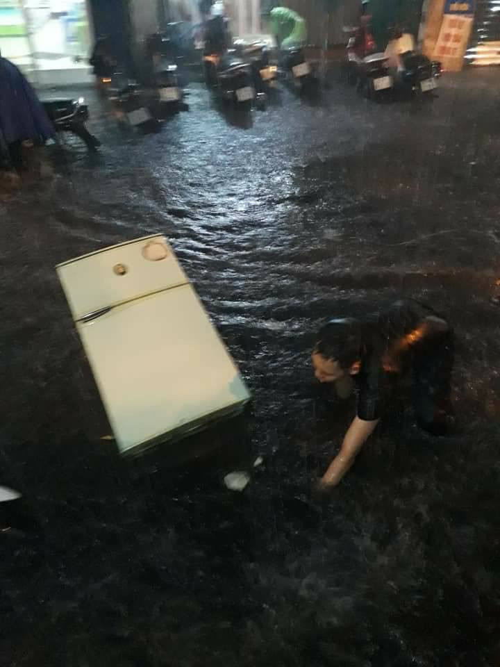 Để rã đông chiếc tủ lạnh của mình, một gia đình tại Hà Nội thậm chí đã phải sử dụng phương pháp ném nó ra trước cửa nhà nơi con phố lênh láng nước ngập.