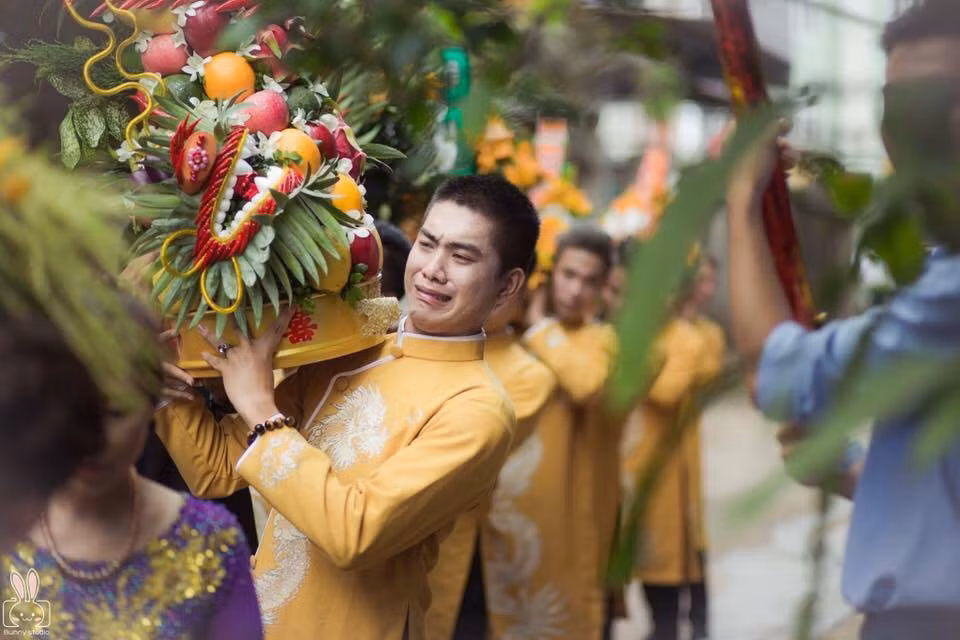 Cũng là công việc bê tráp trong đám cưới nhưng một chàng thì được trao cho tráp cau, nhẹ tênh nên cười vui vẻ, có thời gian tạo dáng trước ống kính. Còn chàng trai 9X bê tráp quả nặng trình trịch trên vai.