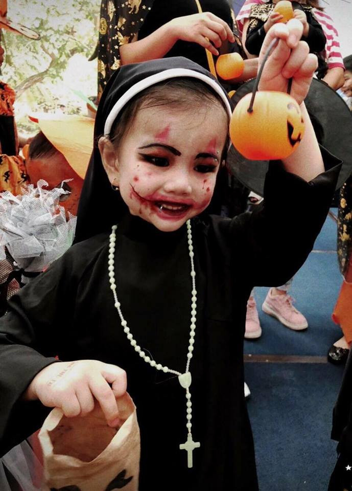 Trong bức ảnh được dân mạng chia sẻ bé Minh Ngọc mặc lên mình bộ quần áo của ma-sơ, dù chưa được vẽ mặt để cho giống Valak nguyên mẫu nhưng cô bé này đã òa khóc và bám thật chặt vào tường khi nhìn mình trong gương.