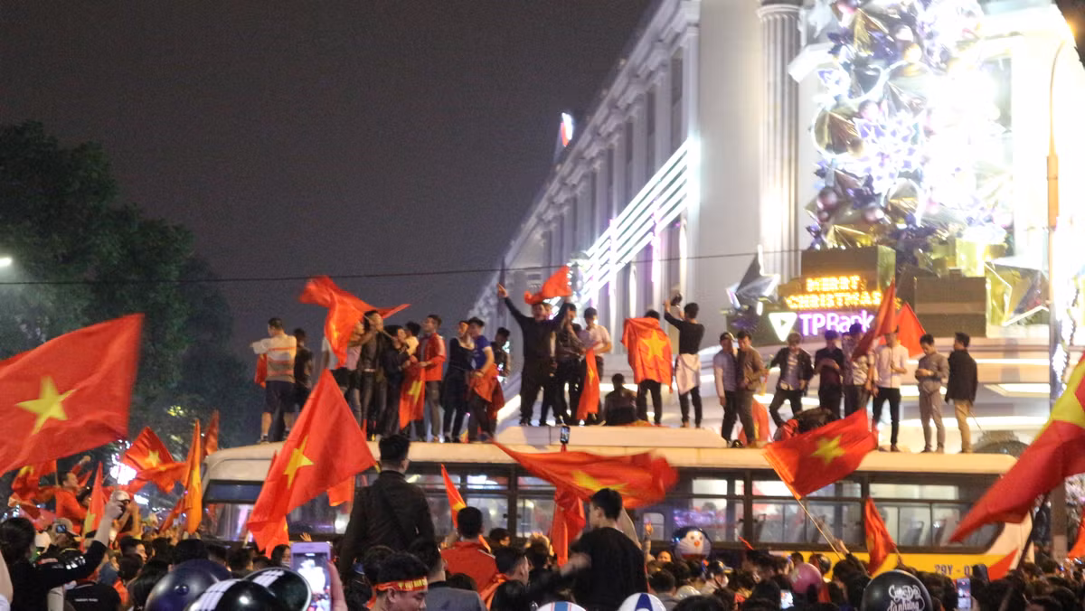 Táo bạo hơn, dòng người đã chặn chiếc xe buýt đang lưu thông trên tuyến phố Hai Bà Trưng để trèo lên nóc ăn mừng và đốt pháo sáng ngay cạnh chiếc xe buýt này. Hành động này thực sự rất nguy hiểm, có thể làm ảnh hưởng đến tính mạng, sự an toàn của rất nhiều người.