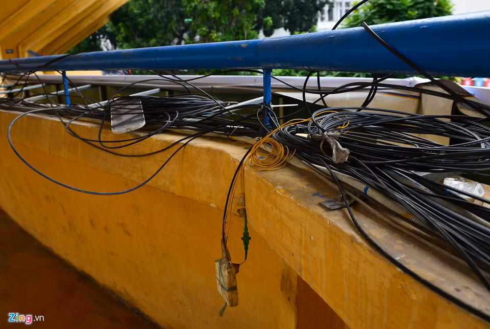 Những sợi dây điện loằng ngoằng được vắng trên lan can của SVĐ Hàng Đẫy hướng ra phố Trịnh Hoài Đức.