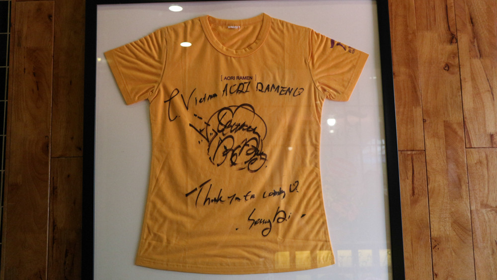 Chiếc áo kỉ niệm có chữ kí tặng của chủ nhân Seungri được đóng khung treo trang trọng giữa nhà hàng Aori Ramen.