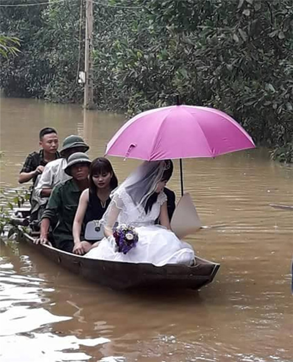 Ngày mưa, phương tiện đón dâu không phải là xe ô tô mà đó là thuyền gỗ.