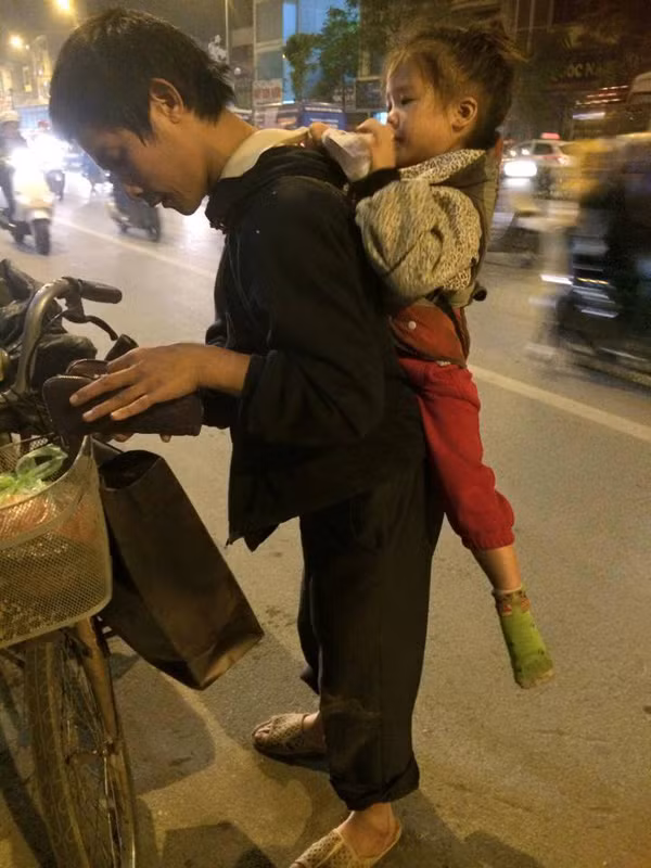 Người cha nghèo cõng con sau lưng đi nhặt rác hàng đêm.
