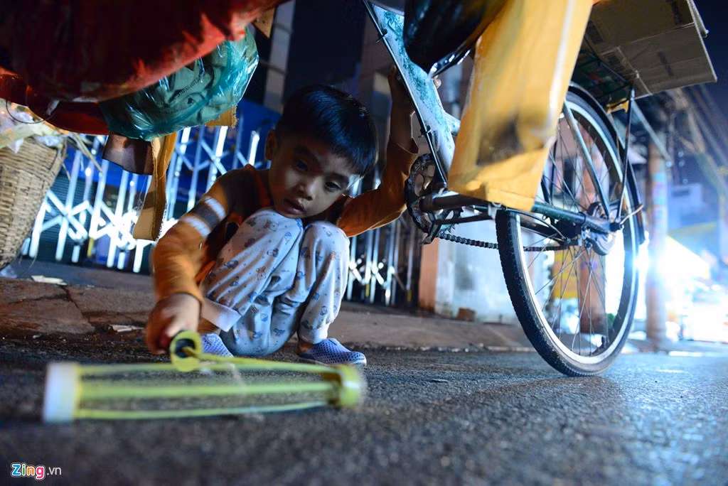 Chị cho biết chỉ có vài chục nghìn trong túi làm vốn, không đủ tiền nên mỗi lần lĩnh từ 5 đến 7 tờ vé số bán, hết thì quay lại lấy đi bán tiếp. Bé Hải Khang trong lúc đợi mẹ thì tìm niềm vui quanh chiếc xe đẩy. Em cũng như hai người anh em của mình không có lễ tết, không có giáng sinh, chỉ có những ngày rong ruổi trên xe ba bánh.