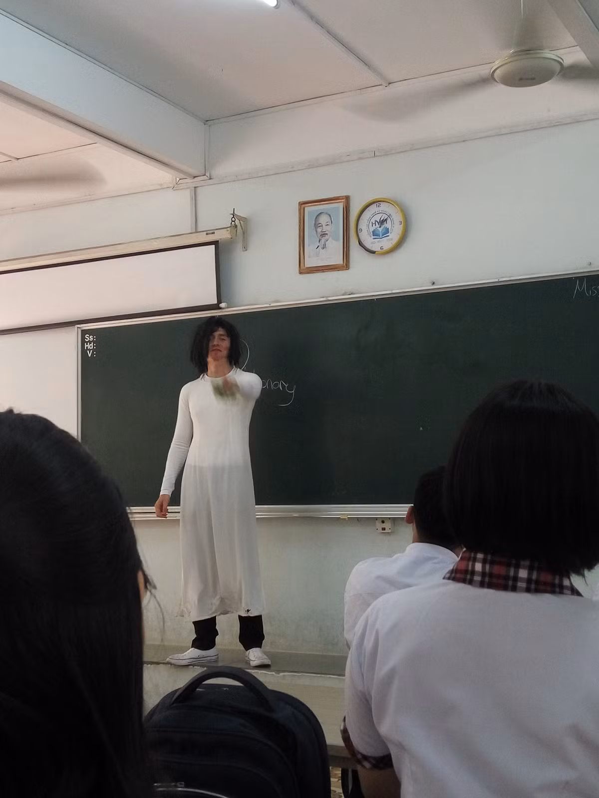 Không chỉ mặc áo dài, đội tóc giả, thầy Chris còn diện hẳn một đôi giày trắng nổi bật, vô tư đứng giảng bài như "không hề có chuyện gì xảy ra".