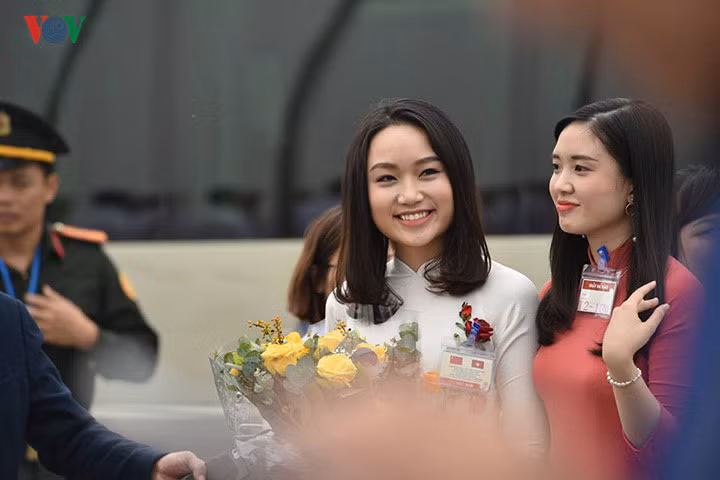 Xuất hiện tại Nội Bài, Thu Trà thu hút ống kính máy ảnh với nụ cười tươi tắn, xinh đẹp cùng bộ áo dài trắng thướt tha, thêu hoa hồng làm họa tiết. Ảnh: Zing