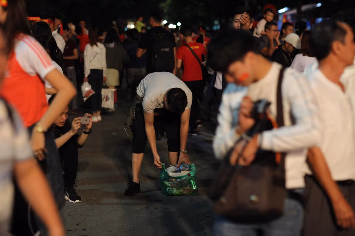 Có mặt tại phố đi bộ Hồ Gươm tối ngày 2/12, sau khi trận đấu của các cầu thủ đội tuyển Việt Nam kết thúc, ai cũng trong tâm trạng phải lấy xe thật nhanh để ra đường chung vui với các CĐV khác thì vẫn còn đó những bạn trẻ ở lại để tìm những chiếc túi ni-lon và cho những mẩu rác vào.