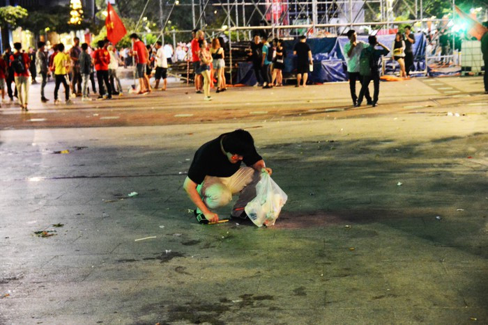 Chàng trai tỉ mẩn nhặt từng que kem tại điểm offline cổ vũ đội tuyển Việt Nam.