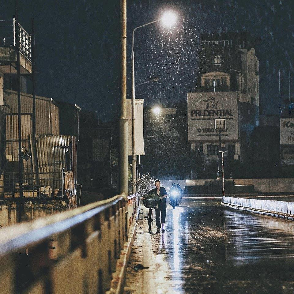 Cảnh người lao động vẫn miệt mài, dắt chiếc xe đạp đi kiếm miếng cơm, manh áo dưới cơn mưa mùa Thu của Hà Nội.