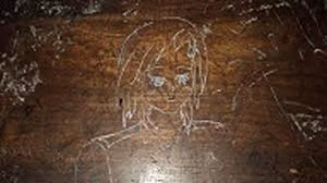 Một bức họa được khắc trên chiếc bàn học.