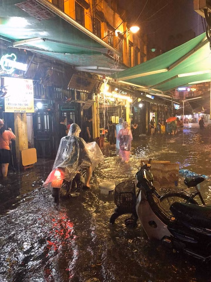 Tại những nơi trong phố cổ như Tạ Hiện, Hàng Buồm, Hàng Điếu, nước ngập đã khiến người dân đi lại khá khó khăn. Nhưng nhiều người dù không phải ra đường những vẫn cố thò chân xuống nước để cảm nhận cái mát của dòng nước mưa.