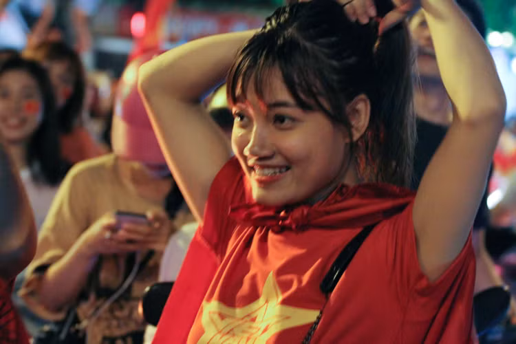 Cô gái này đang chuẩn bị hòa vào dòng người đang hô vang "Việt Nam vô địch".