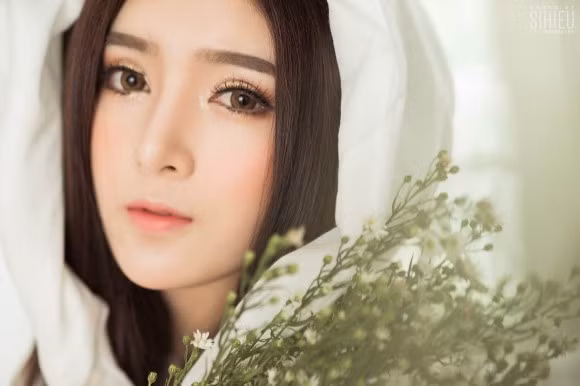 Trong bộ ảnh mới nhất, cô nàng Lilly Luta đã khoe vẻ đẹp ngọt ngào, nữ tính quen thuộc trong chiếc khăn trắng choàng qua đầu bên cạnh những bông hoa sao.