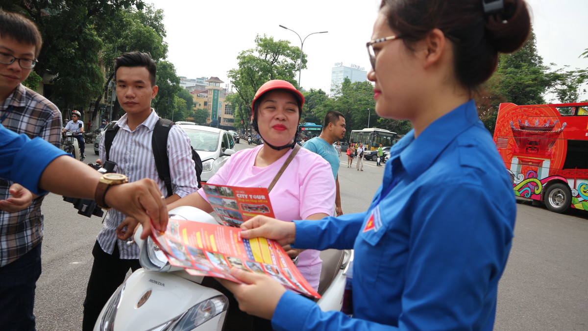 Nhân viên tuyến buýt phát tờ rơi quảng bá cho người dân và du khách về lịch trình của tuyến.