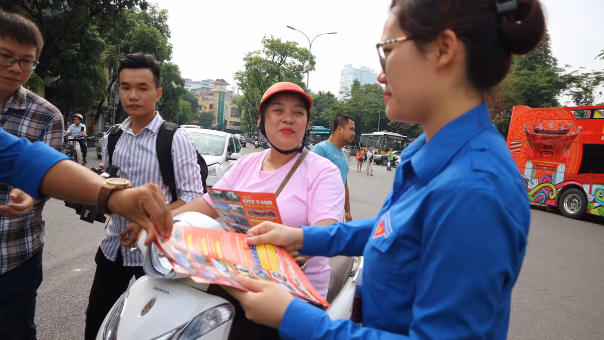 Nhân viên tuyến buýt phát tờ rơi quảng bá cho người dân và du khách về lịch trình của tuyến.