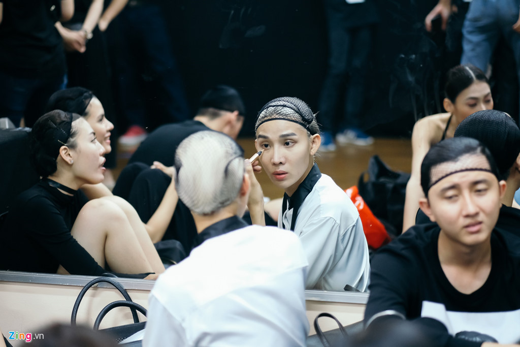 19/4 là ngày đầu của Tuần lễ Thời trang Việt Nam Fashion Week 2018. 17h, các người mẫu diễn bộ sưu tập tối đã có mặt đông đủ ở hậu trường. Phòng trang điểm kín người, người mẫu phải dồn ra hành lang bên ngoài các khu thay đồ dành cho từng nhà thiết kế. Họ quây quần trước tấm gương lớn, vài người tranh thủ tự trang điểm.