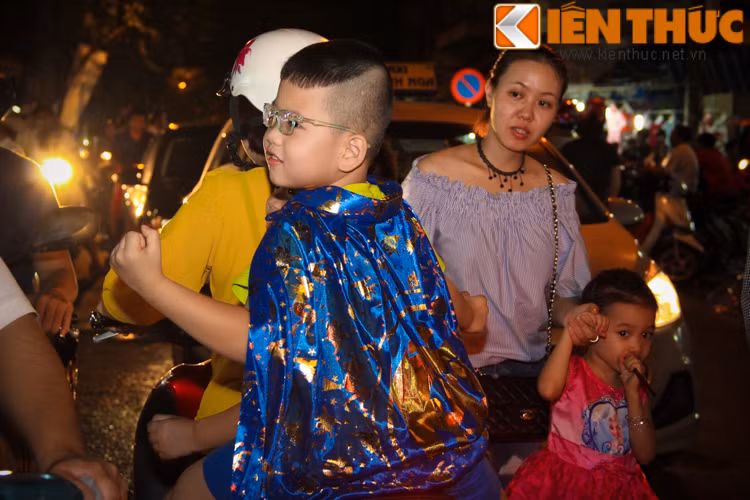 Các em bé được bố mẹ đưa đi chơi trên phố Hàng Mã.